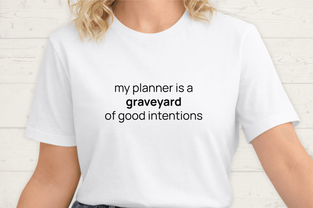 White t-shirt with the phrase "my planner is a graveyard of good intentions."